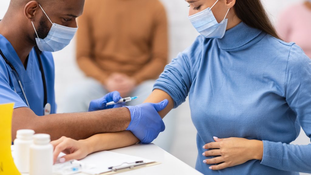 Pregnant Woman Receiving Covid-19 Vaccine Injection In Clinic Room