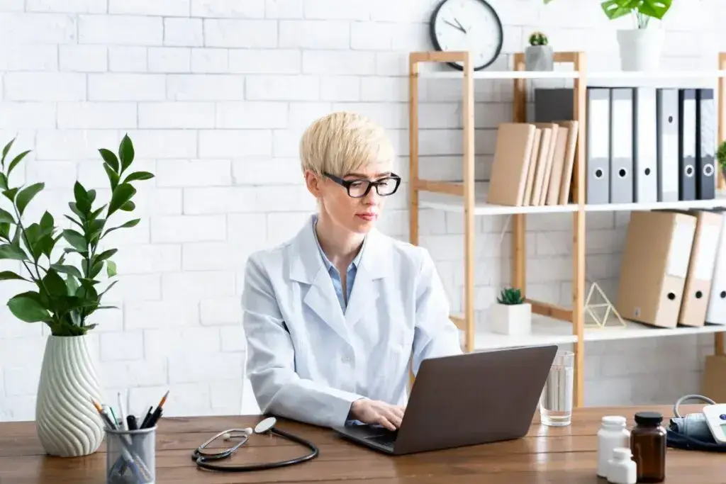 Female doctor using laptop for provider enrollment