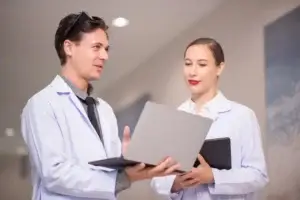 shot-of-two-young-doctors-using-a-tablet-and-havin