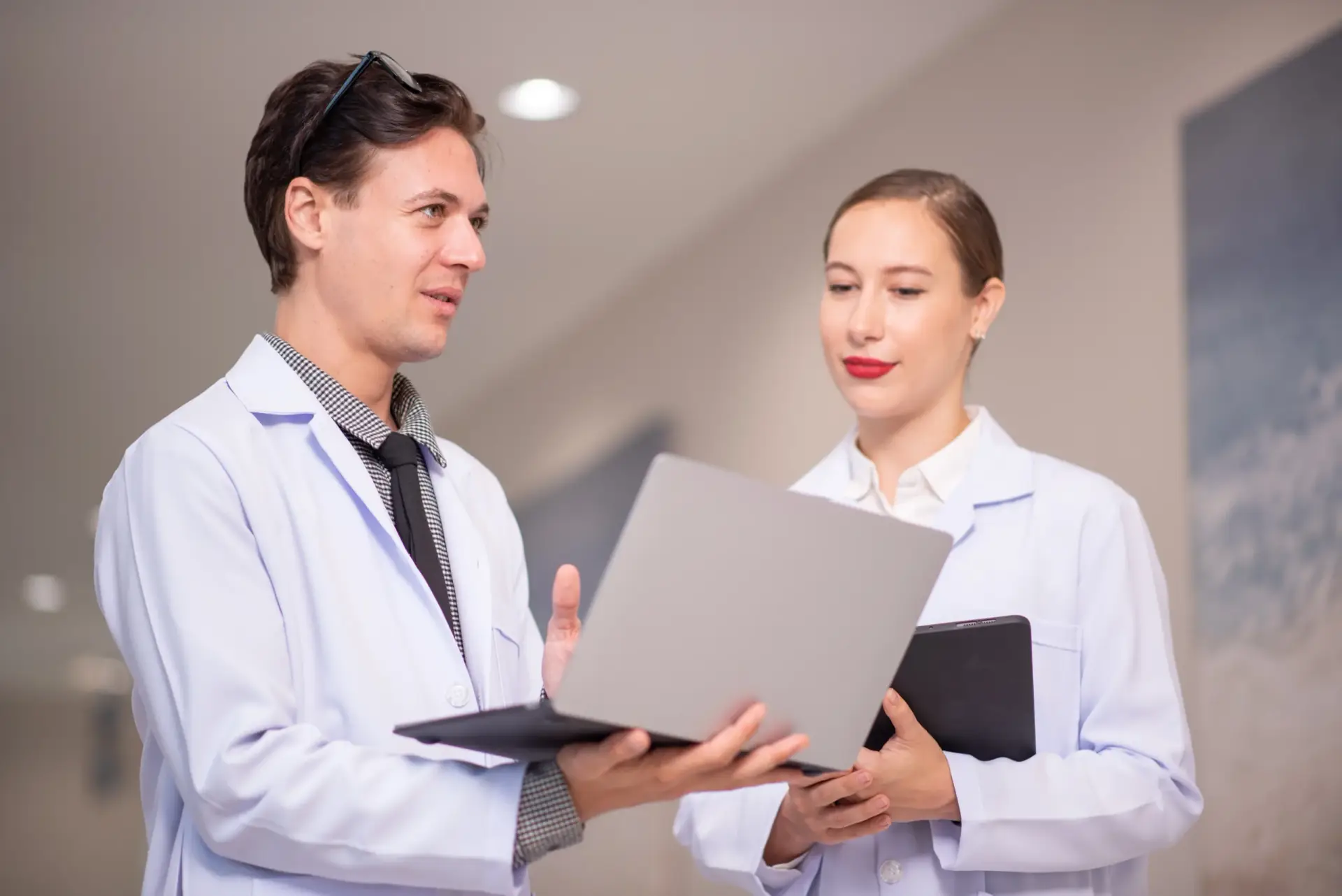 shot-of-two-young-doctors-using-a-tablet-and-havin